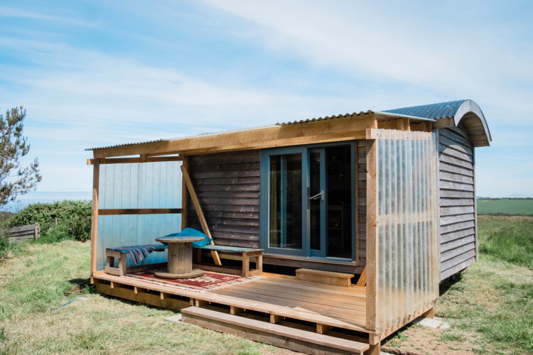Wooden Shepherd's Hut with decking in Cornish campsite field