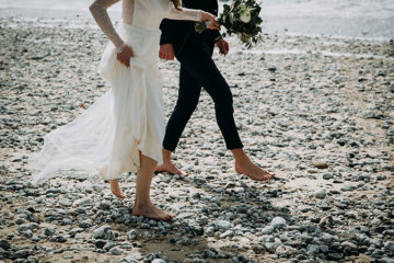 Bride and groom sandy toes on beach on Cornwall wedding day