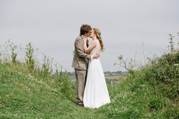 Bride and Groom kissing on wedding day in green countryside