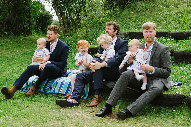 Wedding guests with small children sat on tyres