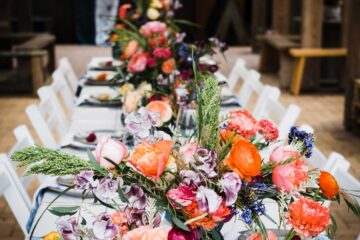 Styled wedding table setting with colour glass jars and bright flowers