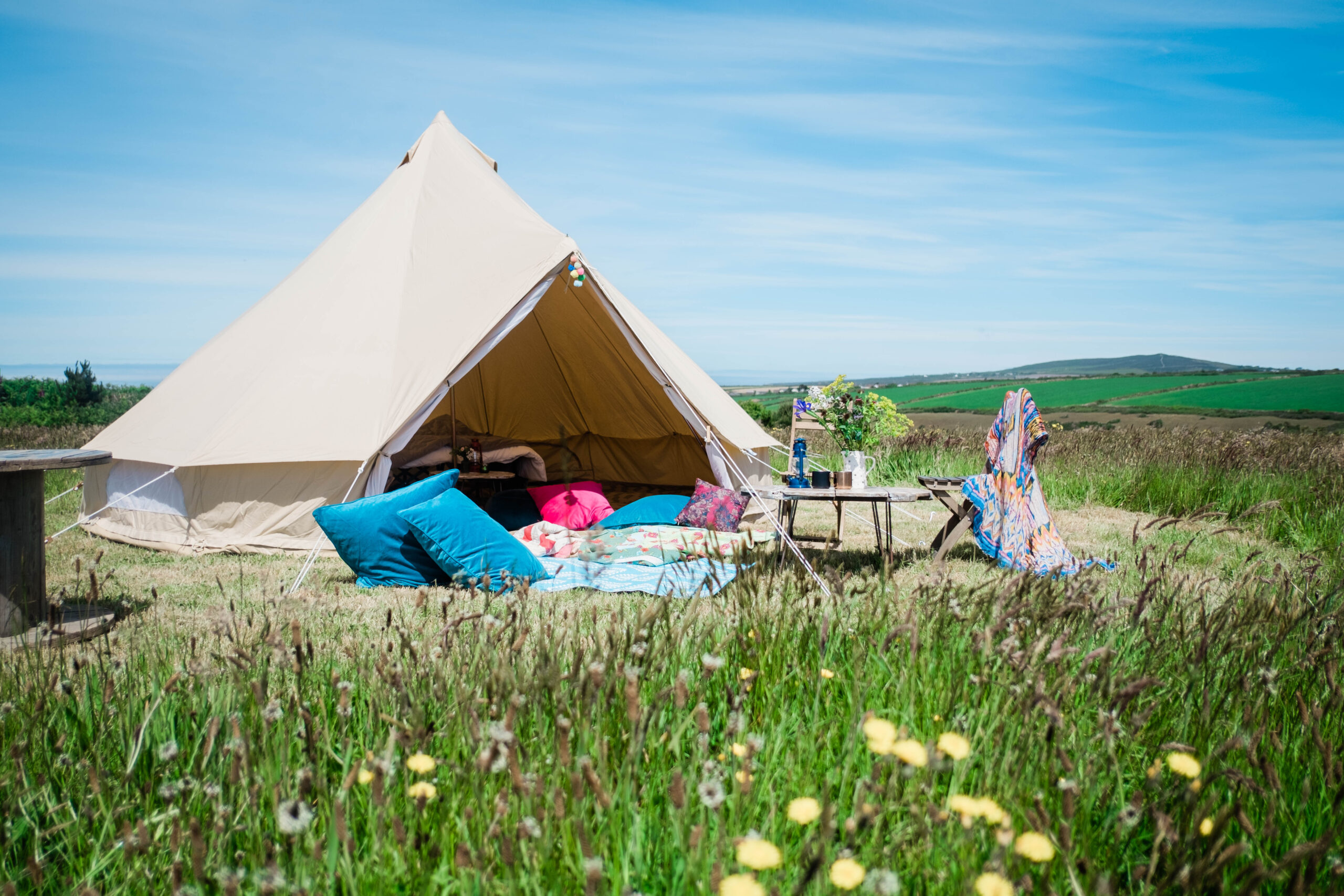 Glamping bell tent set up in Cornwall camping field with blue sky